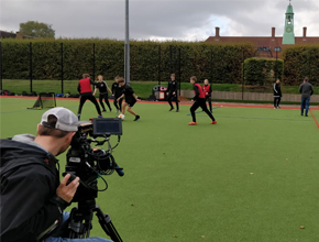 people playing football being filmed